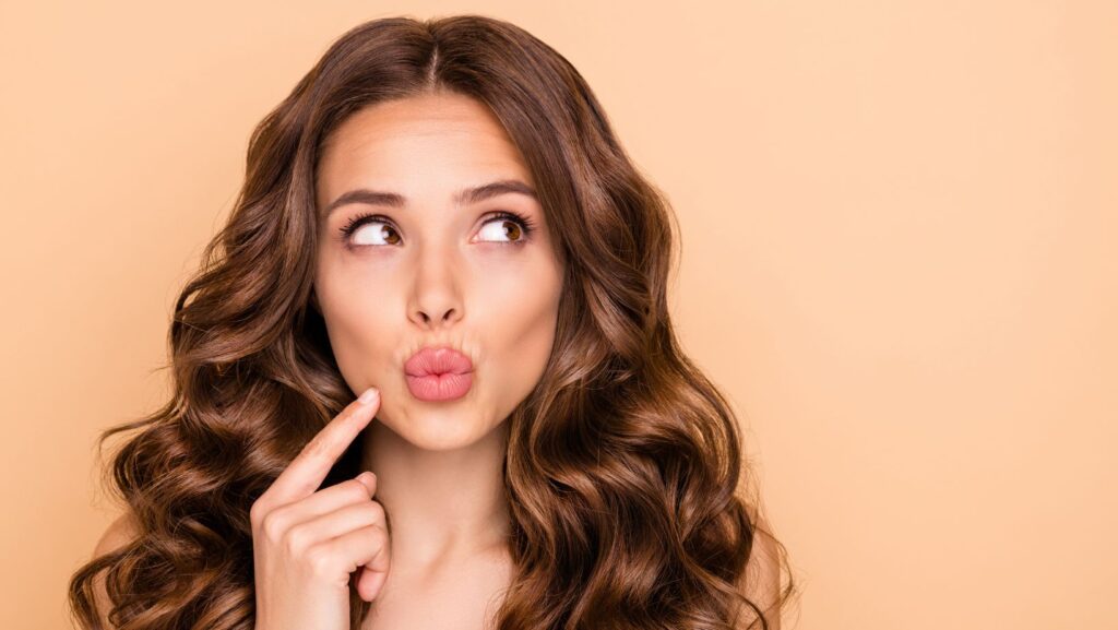 A woman playfully puckering her lips, illustrating the results of a Botox Lip Flip treatment